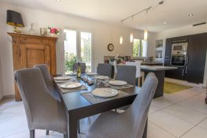 a dining room and kitchen with a table and chairs at Sous le soleil de Lanfon - Maison au Calme avec jardin clos, LLA Selections by Location Lac Annecy in La Pirraz