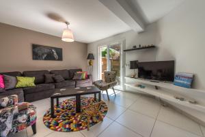 a living room with a couch and a tv at Sous le soleil de Lanfon - Maison au Calme avec jardin clos, LLA Selections by Location Lac Annecy in La Pirraz