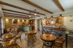 a room with wooden tables and chairs and a kitchen at MARIA'S BOUTIQUE Rooms in Korinthos