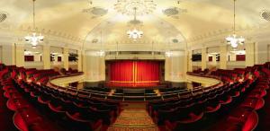 an empty theatre with red chairs and a red stage at Bournemouth Hot Tub & Sauna Holiday Let in Bournemouth
