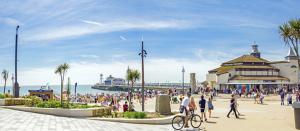 a crowd of people walking on a sidewalk near the beach at Bournemouth Hot Tub & Sauna Holiday Let in Bournemouth