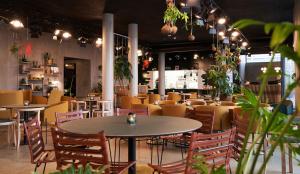 a restaurant with tables and chairs and plants at Hotel GUESTapart in Aarhus