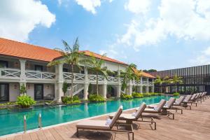 a resort with a swimming pool and lounge chairs at The Barracks Hotel Sentosa by Far East Hospitality in Singapore