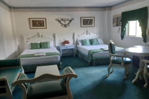 a bedroom with two beds and a table and chairs at SM Travelodge in Batangas City
