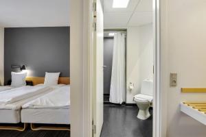 Habitación de hotel con cama y aseo en Hotel Garni en Svendborg