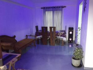 ein lila Wohnzimmer mit einem Tisch und Stühlen in der Unterkunft Villa Amorino in Galle