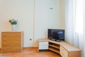 a living room with a tv and a dresser with a dresser at Апартаменты возле МВЦ in Kyiv