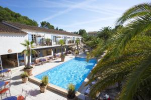 een uitzicht over een zwembad met palmbomen bij La Bastide de Valbonne in Valbonne