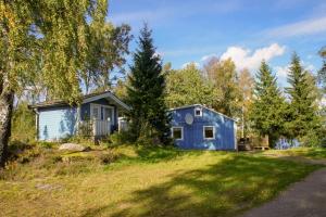 una pequeña casa azul en un patio con árboles en Haus Fegensee, en Kalv