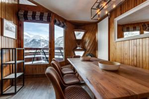 a dining room with a table and chairs and a window at Le Santel 199 in Val dʼIsère +17 photos