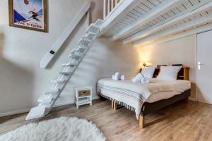 a bedroom with a bed and a spiral staircase at Le Santel 199 in Val-d'Isère
