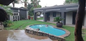 a swimming pool in the yard of a house at AFRICAN DREAMS GUESTHOUSE in Okahandja