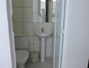 uma pequena casa de banho com WC e lavatório em Consulado Praia Hotel no Guarujá