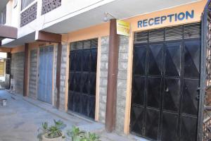 a facade of a building with black garage doors at Viriko Boarding House in Mombasa