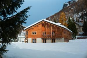 Cabaña de madera con nieve en el suelo en Bed & Breakfast Alchemilla, en Gressoney-la-Trinité