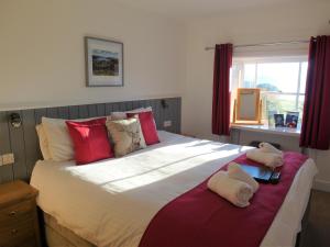 Un dormitorio con una cama grande con dos animales de peluche. en Brathay Hall - Brathay Trust en Ambleside