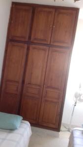 a large wooden cabinet in a bedroom with a bed at Dar el Baraka in Bizerte