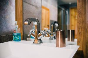 a bathroom sink with two faucets and a mirror at La Maison de Campagne in Kilmuir +45 photos