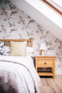 a bedroom with a bed and a table with a lamp at La Maison de Campagne in Kilmuir