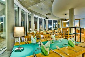 una sala da pranzo con tavolo e sedie blu di Hotel am Fischerstrand a Bansin