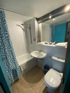 a bathroom with a white toilet and a sink at Hôtel De La Plage in Calais +31 photos