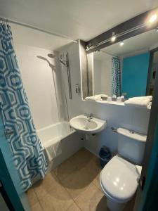 a bathroom with a white toilet and a sink at Hôtel De La Plage in Calais