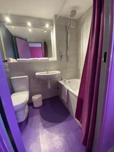 uma casa de banho com um WC branco e um lavatório. em Hôtel De La Plage em Calais