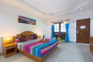 a bedroom with a bed with a colorful striped blanket at Grand View in Patong Beach