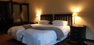 a bedroom with a large bed with white sheets and pillows at AFRICAN DREAMS GUESTHOUSE in Okahandja