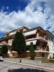 a large building with a tree in front of it at Residenza dei Pini in Civitanova Marche