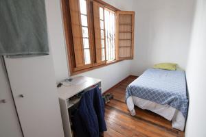 a small bedroom with a bed and a window at Habitación Providencia in Santiago