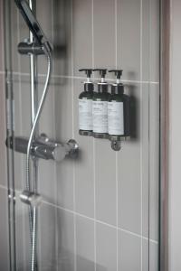two bottles ofodorizers sit on the wall of a shower at Hotel Isbolaget in Donsö