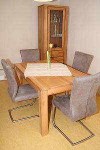 einem Holztisch mit vier Stühlen und einer Vase darauf in der Unterkunft FeWo am Schlossberg in Neusitz