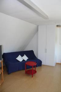 1 dormitorio con 1 cama azul y 1 silla roja en FeWo am Schlossberg, en Neusitz