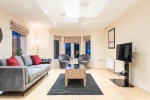 een woonkamer met een bank en een tv bij Modern Smart Open Plan Living with free Parking in York