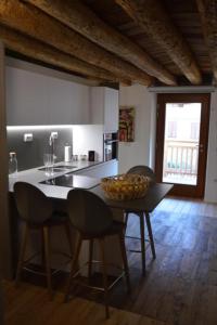 een keuken met een tafel met stoelen en een kom erop bij Le Stanze di Klaus in Rovereto