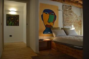 sypialnia z łóżkiem z obrazem na ścianie w obiekcie Le Stanze di Klaus w mieście Rovereto