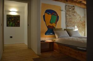 a bedroom with a bed with a painting on the wall at Le Stanze di Klaus in Rovereto