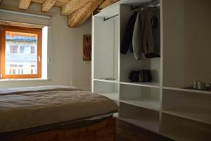 sypialnia z łóżkiem, półkami i oknem w obiekcie Le Stanze di Klaus w mieście Rovereto