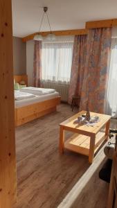 ein Schlafzimmer mit einem Bett und einem Tisch in einem Zimmer in der Unterkunft Gästehaus Scharler in Neukirchen am Großvenediger