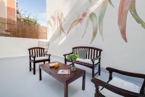 una stanza con tre sedie e un tavolo con un dipinto sul muro di Sweet Inn - Verdi a Barcellona