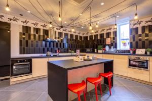 a kitchen with two red stools at a counter at MEININGER Hotel Lyon Centre Berthelot in Lyon