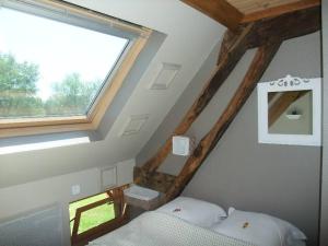 a attic room with a bed and a window at La Maison Du L.A.C. in Simard