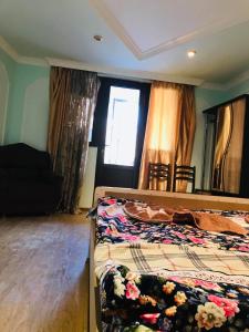 a bedroom with two beds and a couch and a window at Guest House Geno Vardzia Hot Spring in T'mogvi