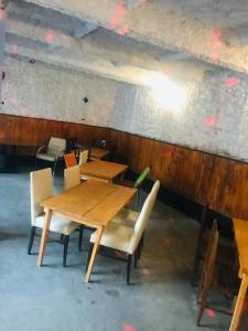 a dining room with wooden tables and chairs at Guest House Geno Vardzia Hot Spring in T'mogvi