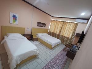 מיטה או מיטות בחדר ב-Indah Inn