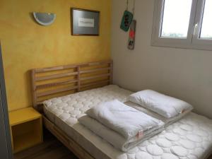 1 Schlafzimmer mit 2 Betten mit weißer Bettwäsche und einem Fenster in der Unterkunft Das Haus auf der Düne in Plouescat