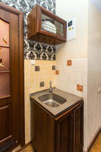 a bathroom with a sink and a wooden cabinet at Квартира в оренду на Копеника 12, біля Палацу Потоцьких in Lviv