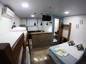 イーリャ・グランデにあるCasa da Ilhaのベッド2台とキッチンが備わる小さな客室です。