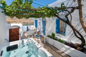 a soaking tub in the yard of a house with a tree at Lindos Beach Boutique Villa in Líndos